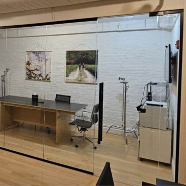Glass partition system in modern office interior with natural light and open design